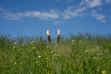 Boy amidst grass against blue sky