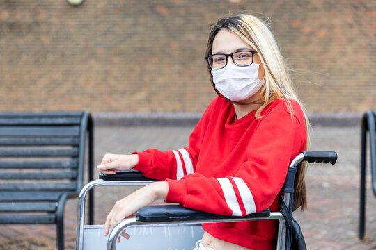 Disabled woman on wheelchair wearing face mask during coronavirus outbreak