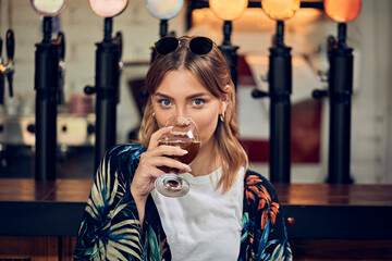 Portrait of a smiling woman in a pub having a beer