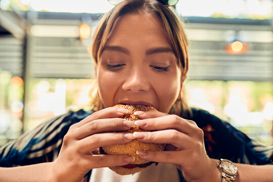 Portrait Of Woman Eating A Burger