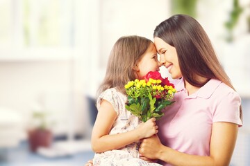 Happy Mother and daughter hugging with flowers
