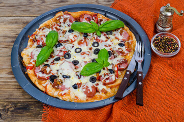 Homemade pizza with salami, mozzarella and olives