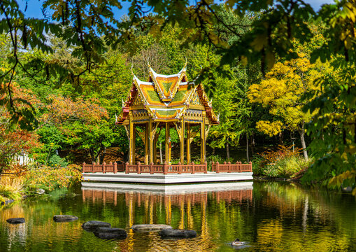 Thail&auml;ndische Sala mit Buddha-Statue im Westpark, M&uuml;nchen - farbefrohe herbstliche B&auml;ume und Spiegelung im See