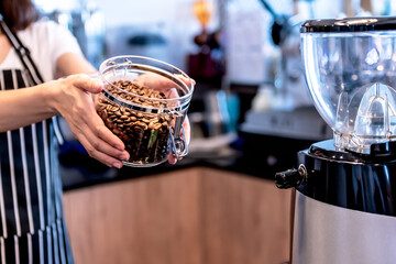 Close up images of Coffee shop owner Show quality coffee beans that are roasted and cooked, in a glass jar, to people and drink concept.