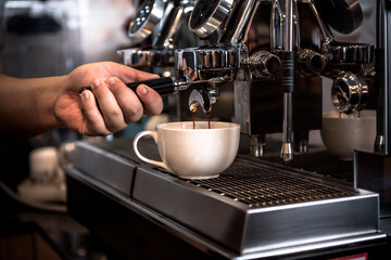 Coffee shop owner or barista using Automatic coffee machines are working by distilling concentrated coffee water, for business and  drink concept.
