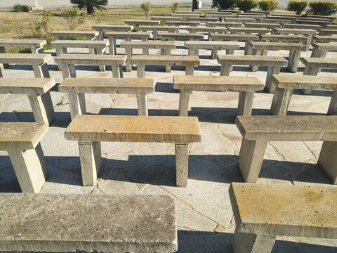 Stone benches in rows near Sant'Efisio church in Pula, Sardinia, Italy