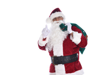 Fototapeta na wymiar Senior man in traditional Santa Claus costume with a bag of toys over his shoulder and pointg wiht the other hand. Isolated on white.