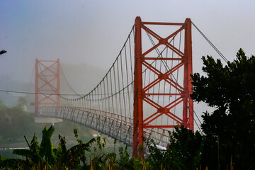 Sekrikil suspension bridge in Parakan city, Central Java, Indonesia on a foggy morning