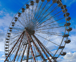 Low angle view of a ferris wheel against a blue sky