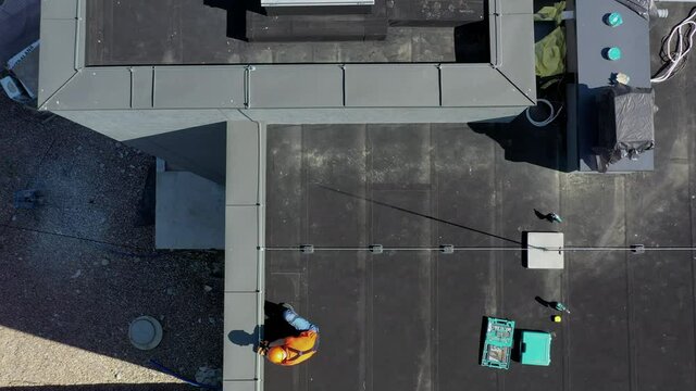Professional Caucasian Worker in Hard Hat Finishing Lightning Protection System on Top of the Building