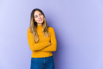 Young caucasian woman isolated on purple background dreaming of achieving goals and purposes