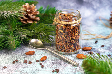 Homemade granola with chocolate and nuts in a glass jar. New year concept. On a gray background. Vegetarian dish.