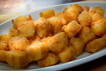 Breaded cheese dumplings appetizer, on a white platter