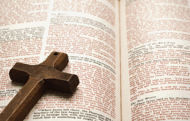 Wooden cross on open Bible.