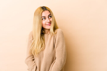 Young blonde caucasian woman dreaming of achieving goals and purposes
