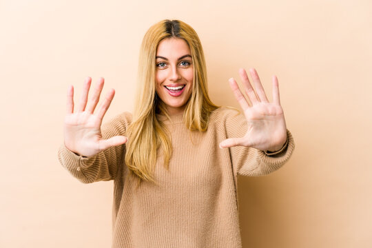 Young blonde caucasian woman showing number ten with hands.