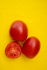 Red tomatoes on a yellow background