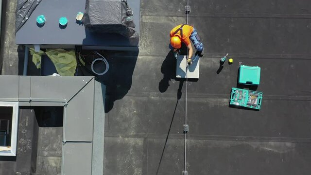 Aerial View of Caucasian Technician Adjusting Metal Rod of Building Lightning Protection System