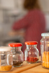 row of glass jars with black and red peppercorn. Selective focus
