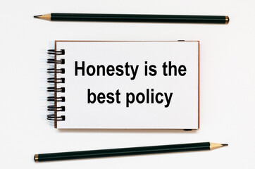 WHITE SPIRAL NOTEBOOK, TWO PENCILS WITH TEXT honesty is the best policy