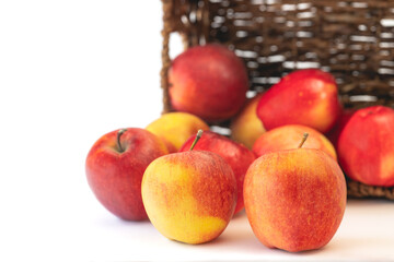 Red apples close up. Fresh organic fruits in a wicker basket isolated on white background with copy space.