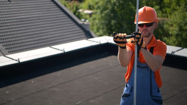 Technician Attaching Two Lightning Protection Rods to Each Other and Finishing Protection System Building.