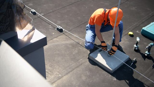 Modern Building Lightning Protection Technologies. Technician Assembly Metal Rod on the Roof.