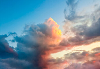 Heavenly sunset cumulus clouds colored in purple beige tones high in azure sky