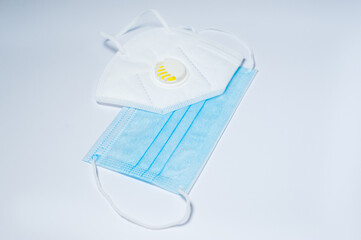 Respirator with exhalation valve and medical protective mask isolated on a white background