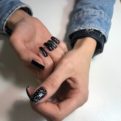 Stylish trendy black female manicure.Hands of a woman with black manicure on nails