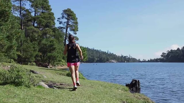Mujer joven de trail running corriendo en la monta&ntilde;a al aire libre, haciendo entrenamiento de resistencia. Estilo de vida saludable y disciplina deportiva