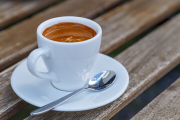 Cup of coffee on table in coffee shop cafe.A cup of coffee and coffee beans with croissant on the table