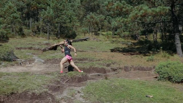 Mujer joven de trail running corriendo en la montaña al aire libre, haciendo entrenamiento de resistencia. Estilo de vida saludable y disciplina deportiva