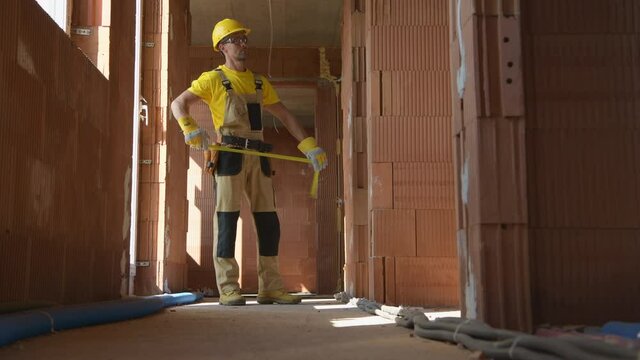 Caucasian Construction Site General Manager Measuring Building Interior Elements To Make Sure Everything Has Been Done Correctly.
