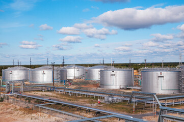 Cloudy day. Tanks with oil for further transportation of oil through pipes at an oil refinery and oil pumping station