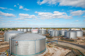 Cloudy day. Tanks with oil for further transportation of oil through pipes at an oil refinery and oil pumping station