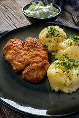 Pork chop served with mashed potatoes and cucumber salad.