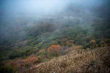 mountains at sunset in fog and gray clouds