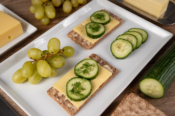 Rye crispbread with cheese, cucumber slices and cress