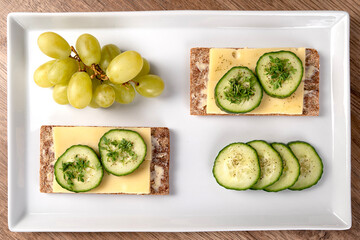 Rye crispbread with cheese, cucumber slices and cress