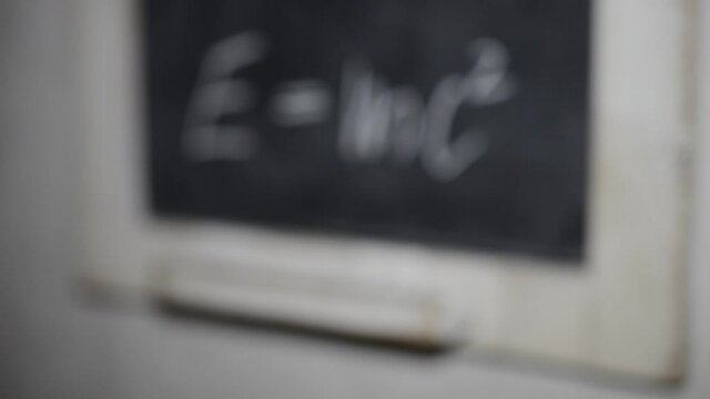 Einsteins formula written chalk on a slate