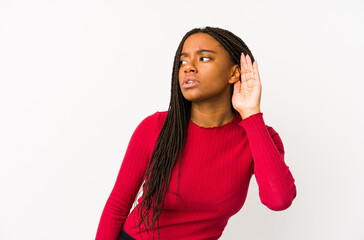 Young african american woman isolated trying to listening a gossip.