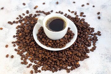 A cup of delicious aromatic coffee. It is placed on a substrate made of coffee beans. New Year holiday concept. On a light background.