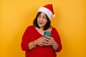 Image of a happy young beautiful woman posing isolated over bright background listening to music with earphones using mobile phone.