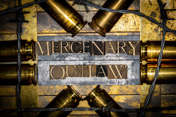 Mercenary Outlaw text message on lead bar between copper 50 caliber gun casings on vintage textured grunge copper and gold background with barbed wire