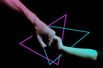 Two hands fist bump over a brightly coloured neon background