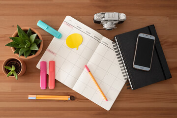 School stationery and supplies. Blank diary, black notebook, marks, vintage camera and mobile phone. Top view.