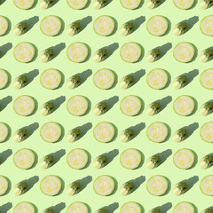 Zucchini isolated on a green background. Seamless pattern of zucchini on a mint background. Flat layout of sliced zucchini slices. Creative composition on the theme of dietary nutrition. Top view.