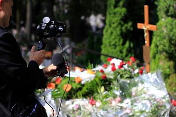 The professional man transmitting the funeral live. Funeral recording. Cameraman at the cemetery recording the burial. Funerals online. Funerals live.