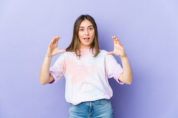 Fototapeta premium Young caucasian woman holding something with palms, offering to camera.